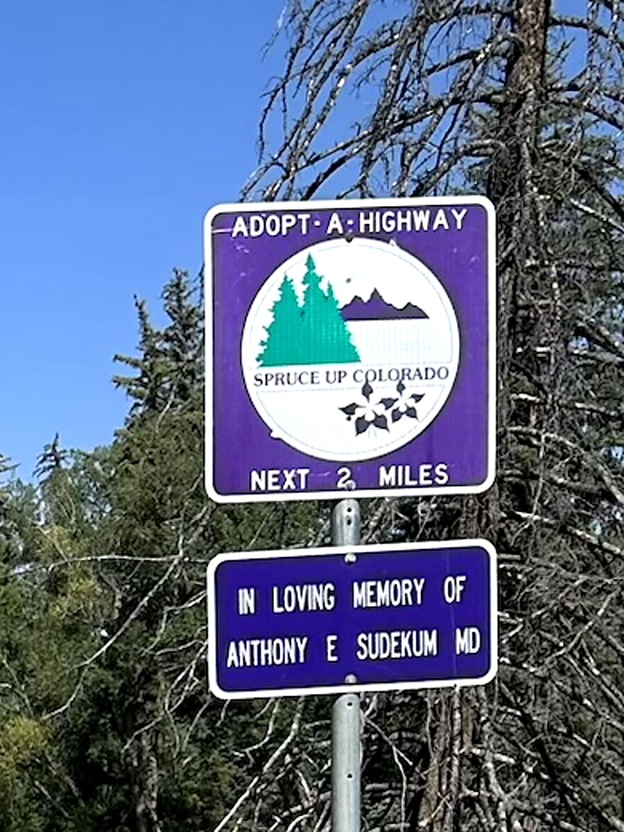 Close-up of the Adopt-a-Highway sign reading In Loving Memory of Anthony E. Sudekum, MD